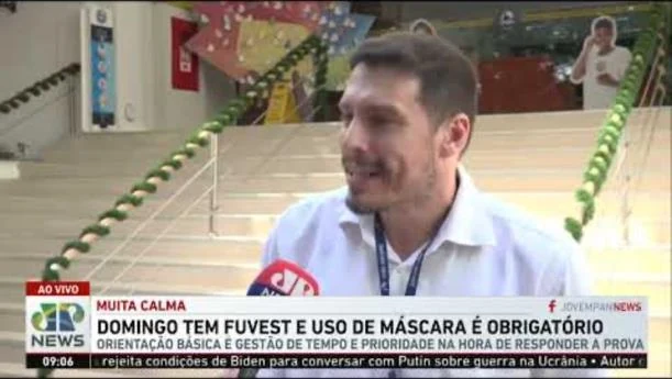 Transmissão ao vivo da Jovem Pan News dentro do Anglo Morumbi, com a manchete “Domingo tem Fuvest e uso de máscara é obrigatório”.