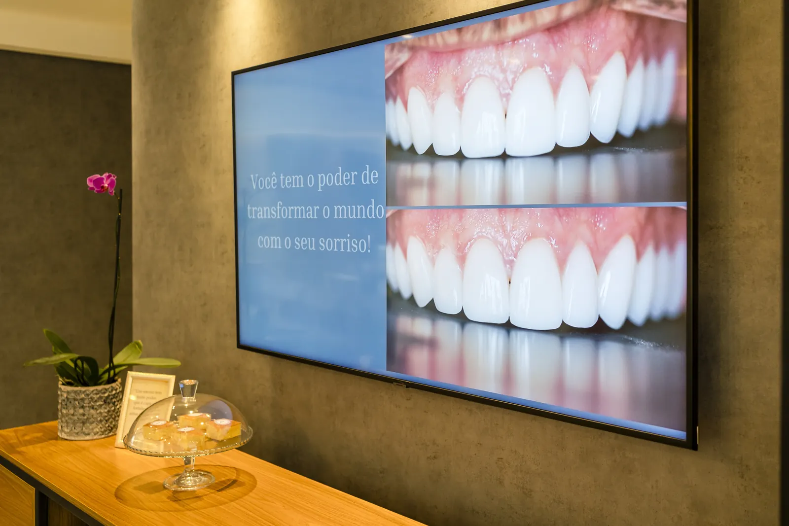 Recepção com a televisão exibindo conteúdo sobre sorrisos.