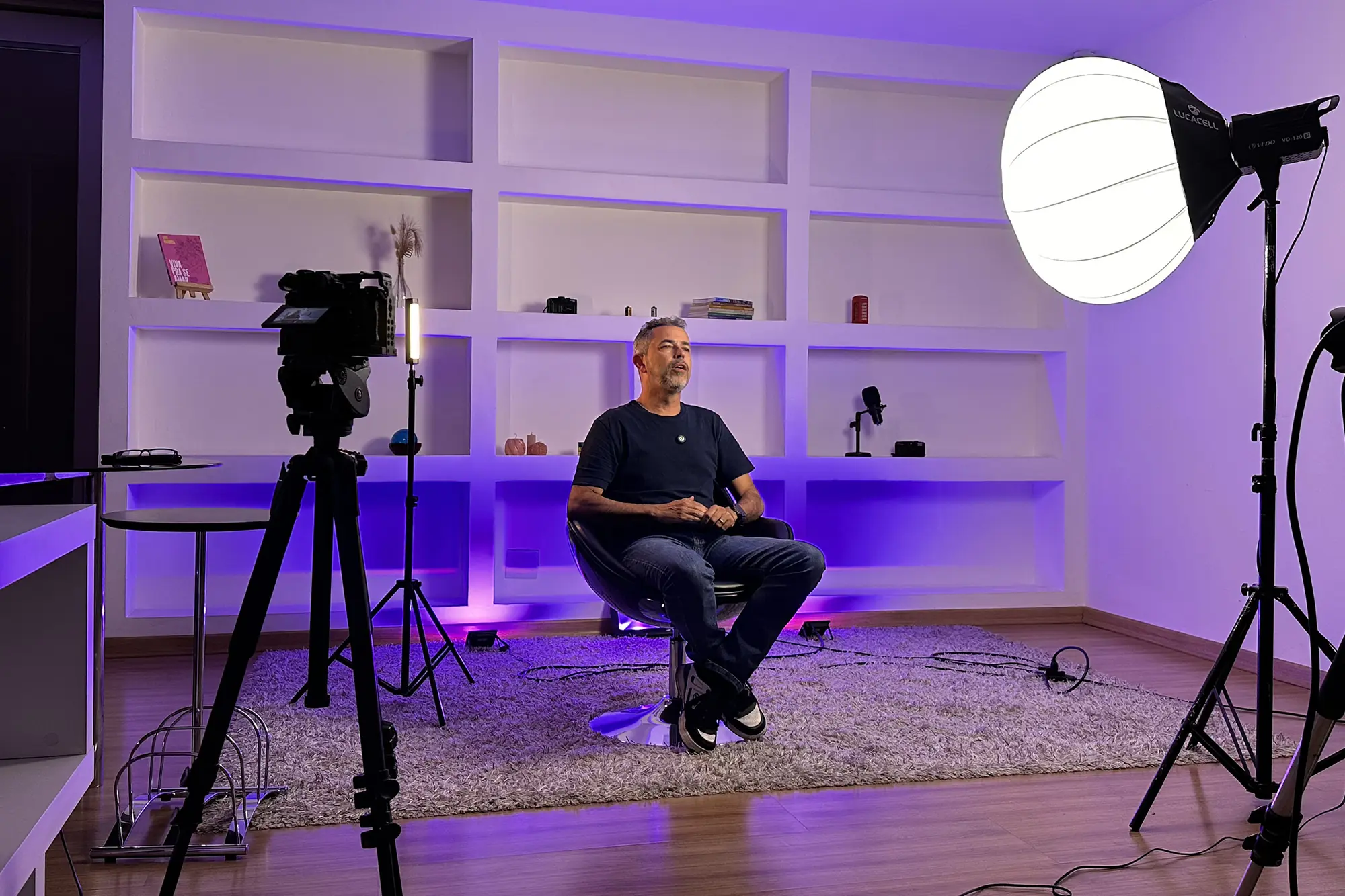 Paulo Manso sentado em entrevista no estúdio da Buzz 360, entre câmeras e iluminação.